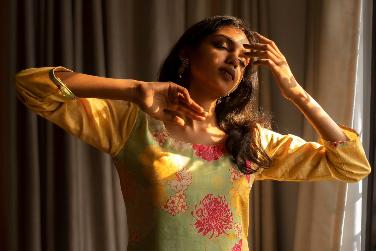 Yellow floral kurti and green stoned earrings