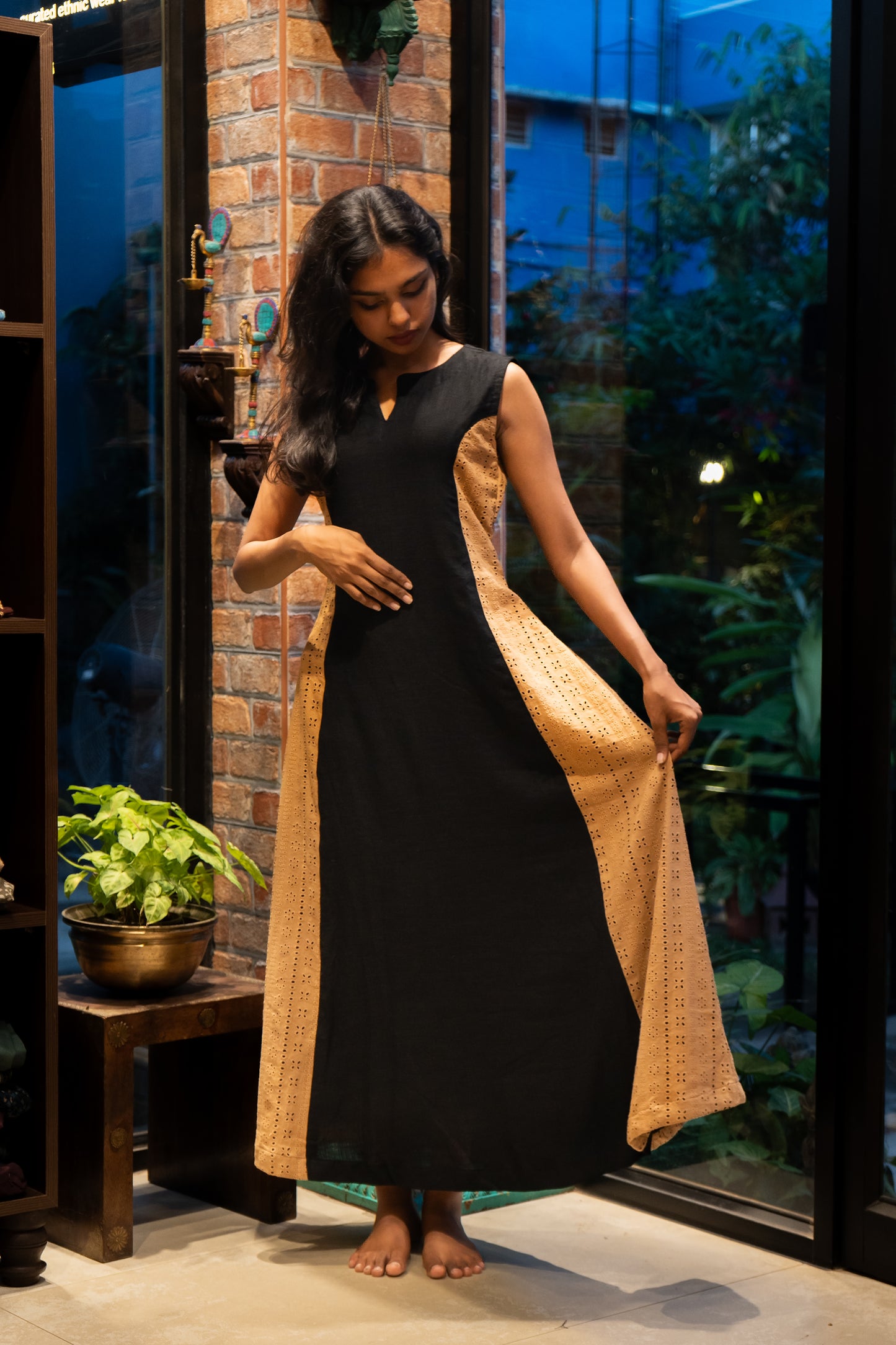 Styled look of black linen sleeveless A-line dress with split neck and Hakoba panels, ideal for casual and office wea