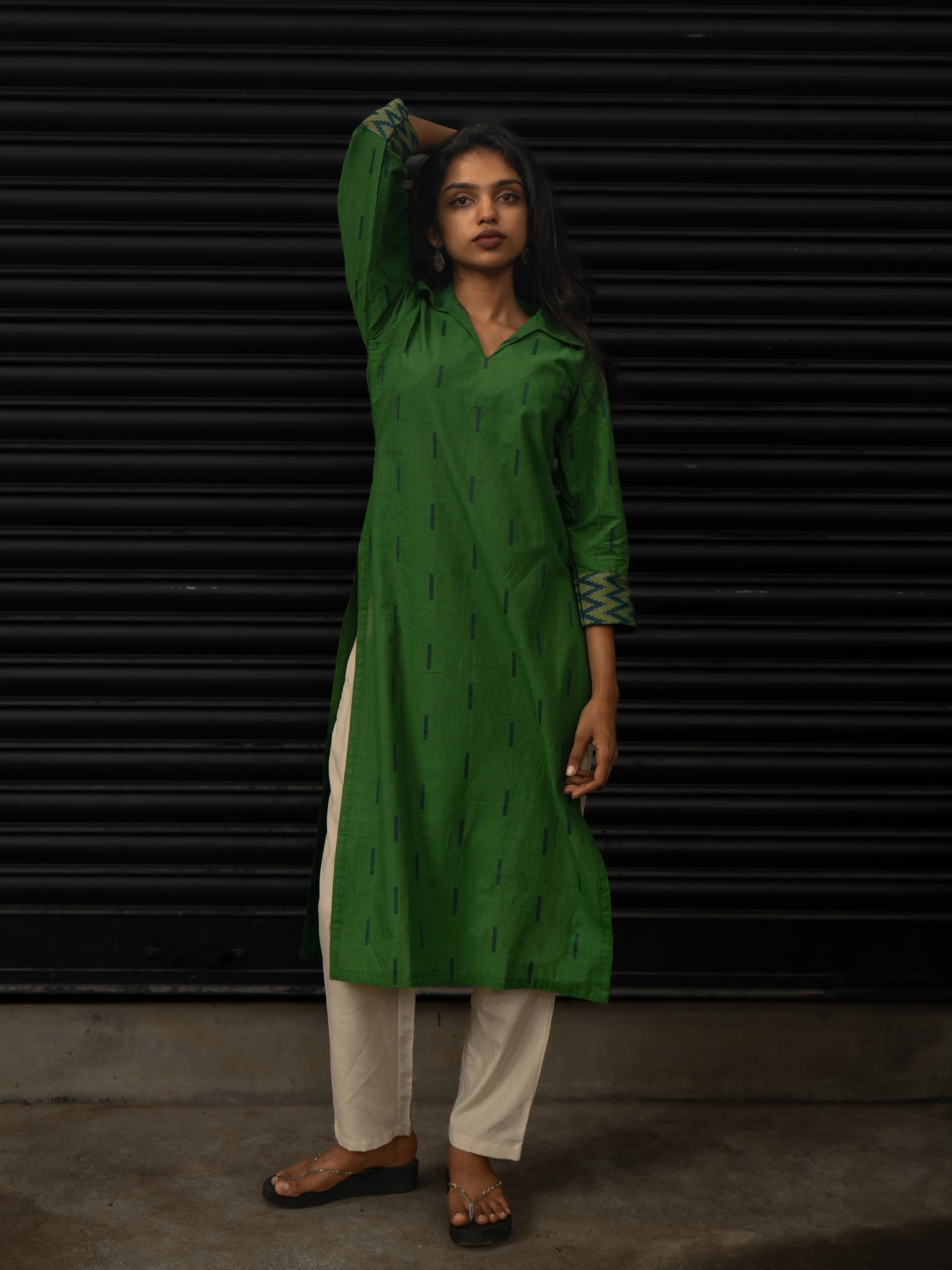 Green handloom cotton kurti with dark blue line patterns, T-shirt collar, 3/4th sleeves with woven zig-zag borders, front view, in-house stitched.