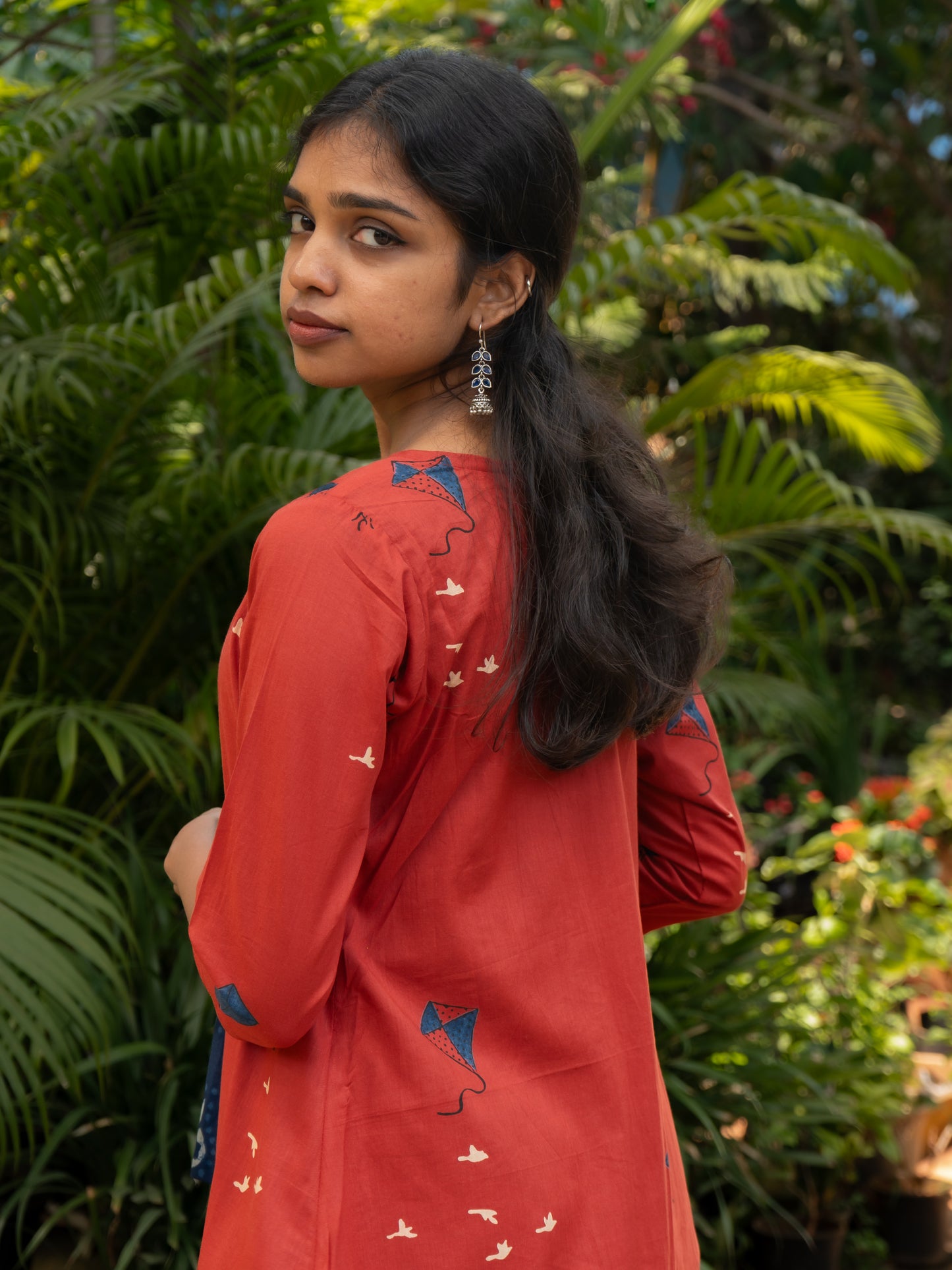 Styled layered look of indigo sleeveless cotton top and red kite printed long cotton cape jacket from Sakyaa's ethnic fusion collection