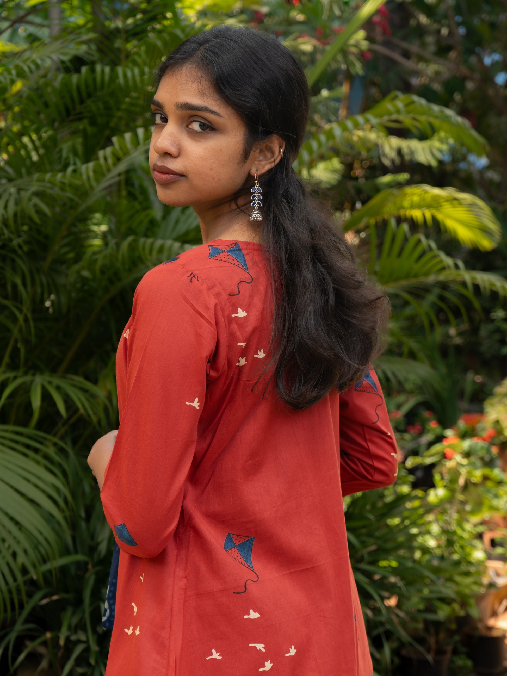 Styled layered look of indigo sleeveless cotton top and red kite printed long cotton cape jacket from Sakyaa's ethnic fusion collection