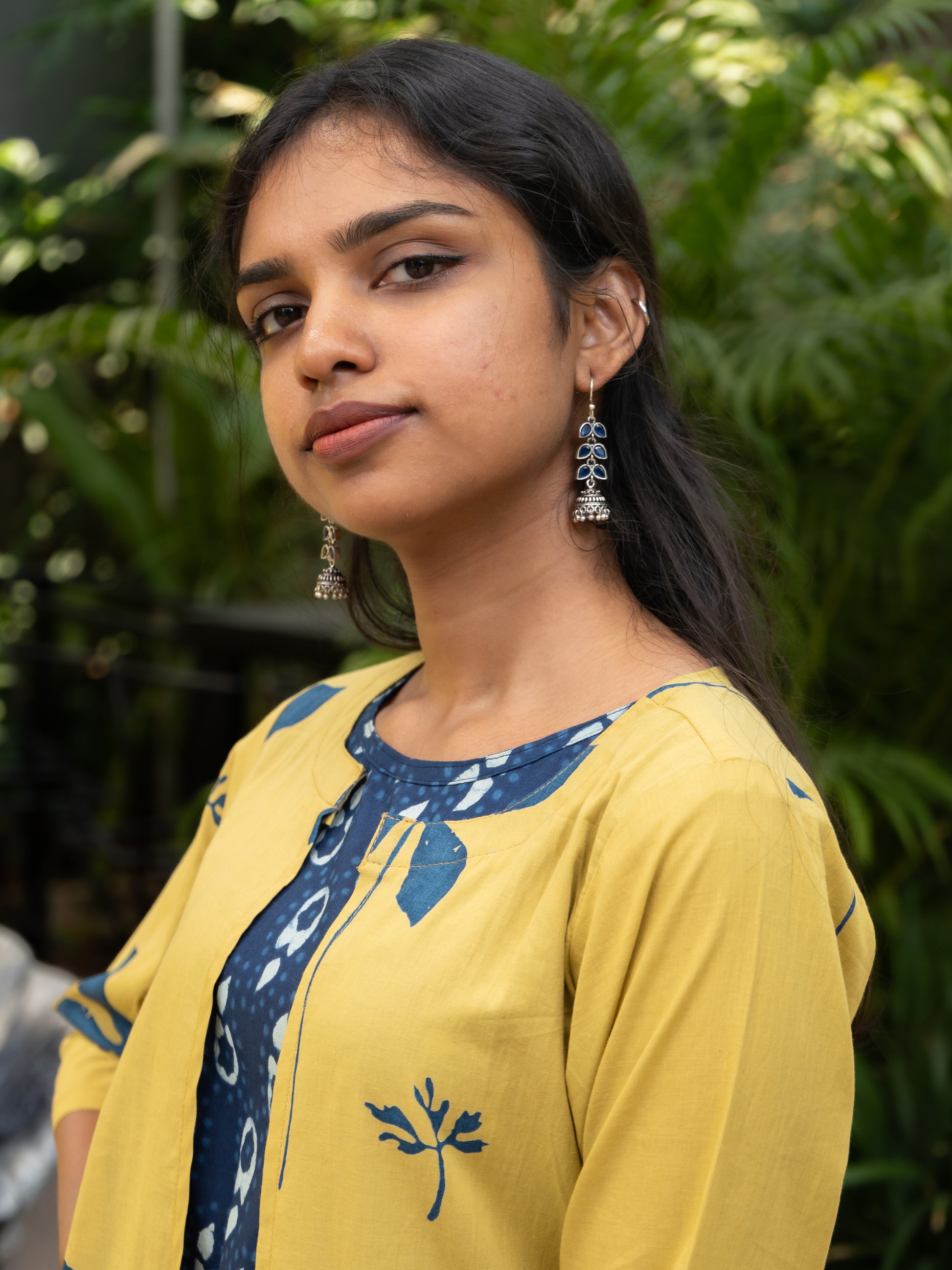 Styled look of indigo cotton top layered with yellow floral printed long cotton cape jacket from Sakyaa's ethnic fusion collection