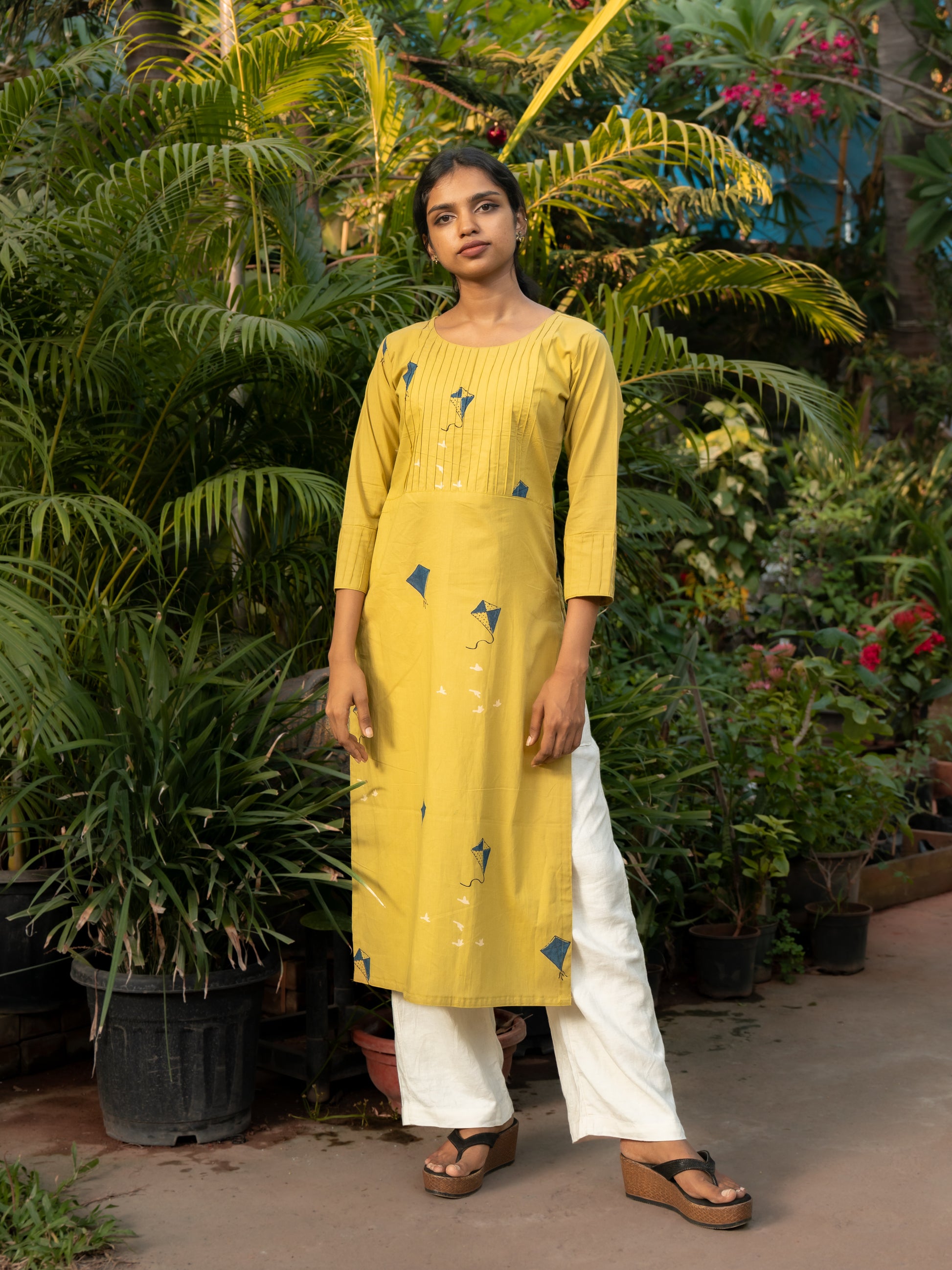 Styling look of long yellow cotton kurti with side slits, perfect for casual wear and office outfits