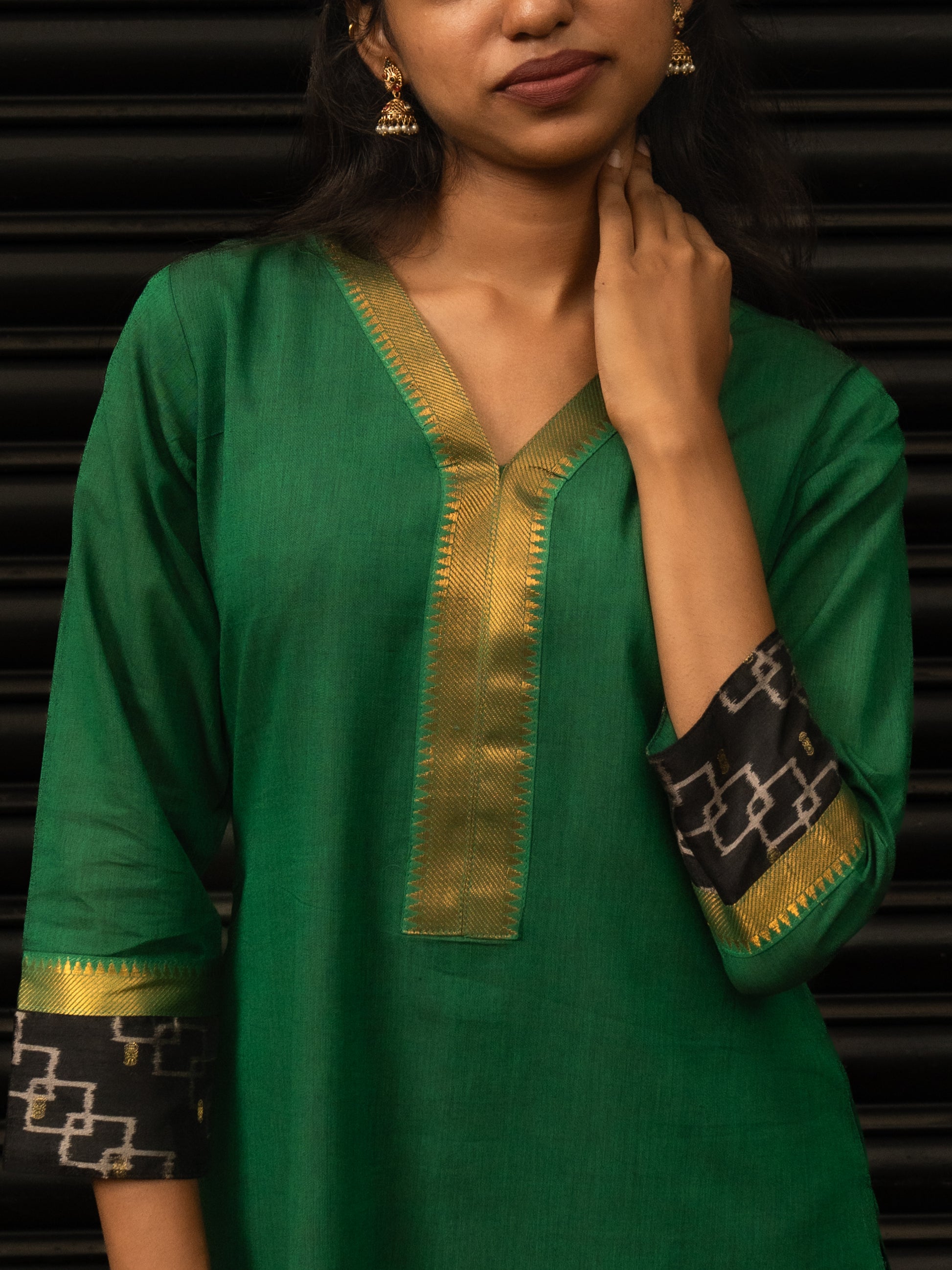 Close-up of gold accents and V-neck on green Mangalgiri cotton kurti with lining, handcrafted in-house by Sakyaa tailors.