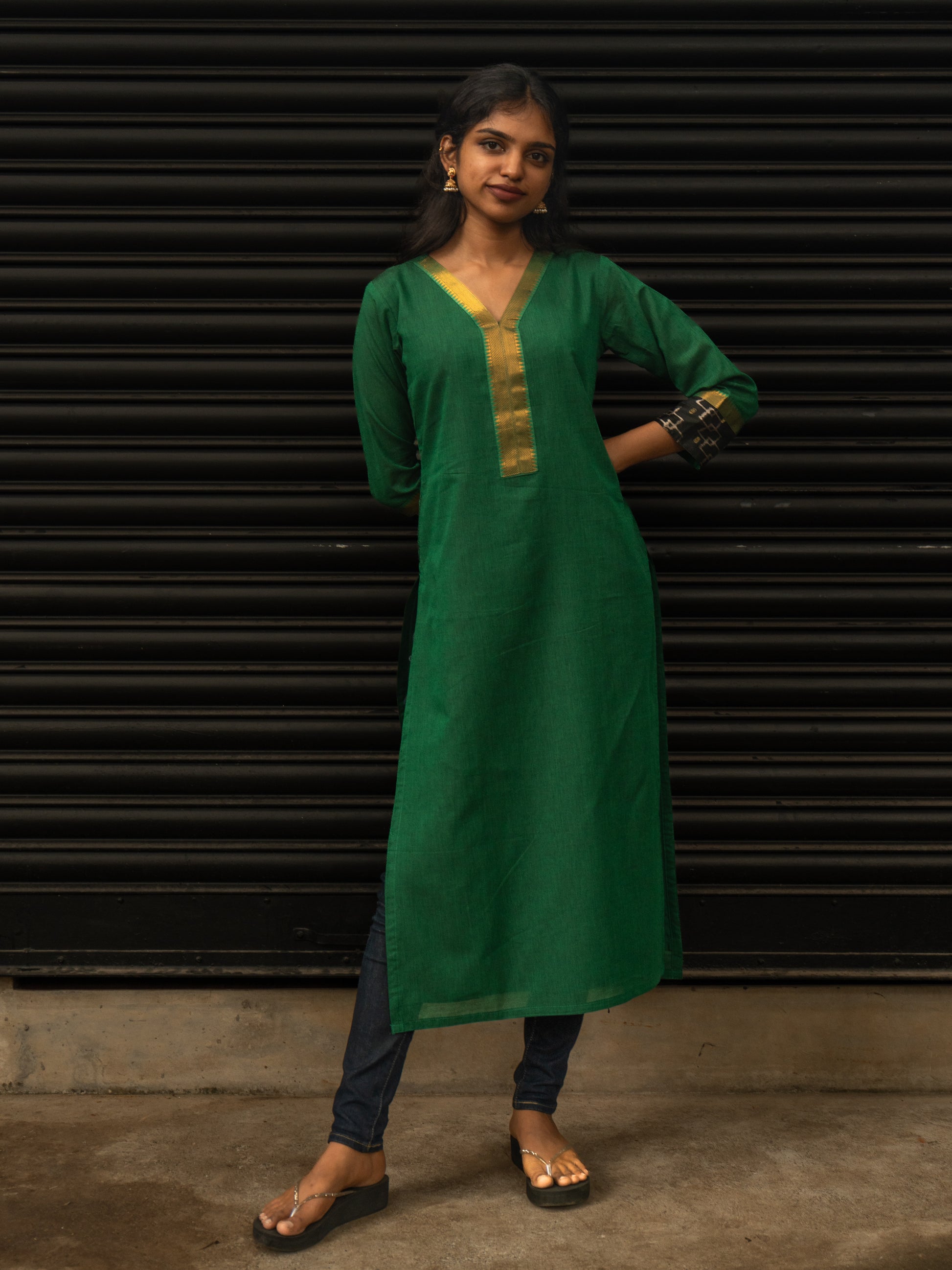 Front view of green Mangalgiri cotton kurti with gold detailing, black Pochampally sleeve borders, V-neck, 3/4th sleeves, handcrafted in-house by Sakyaa tailors.