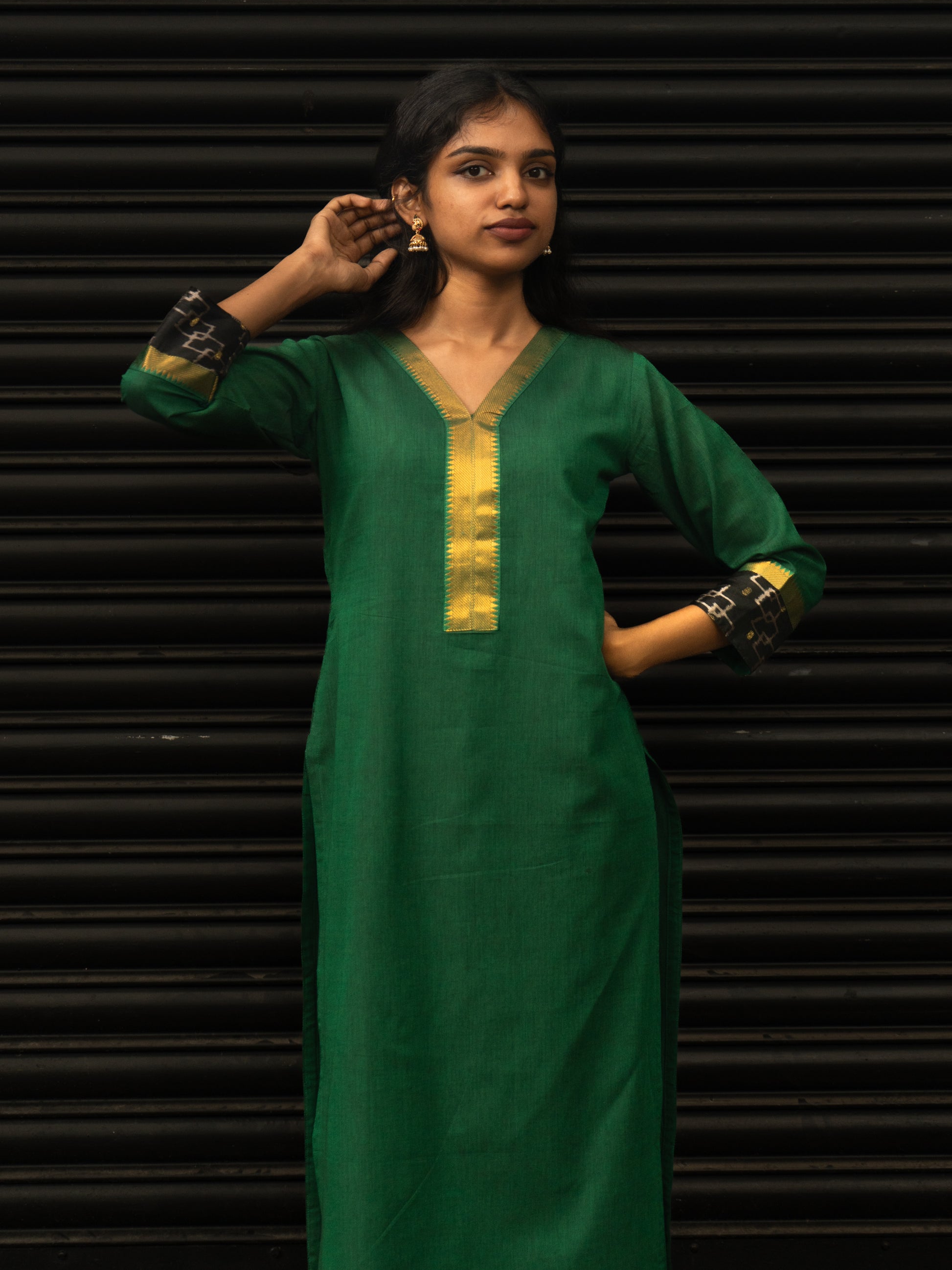 Mid-length view highlighting black Pochampally sleeve borders and gold detailing on green Mangalgiri cotton kurti, in-house stitched by Sakyaa.