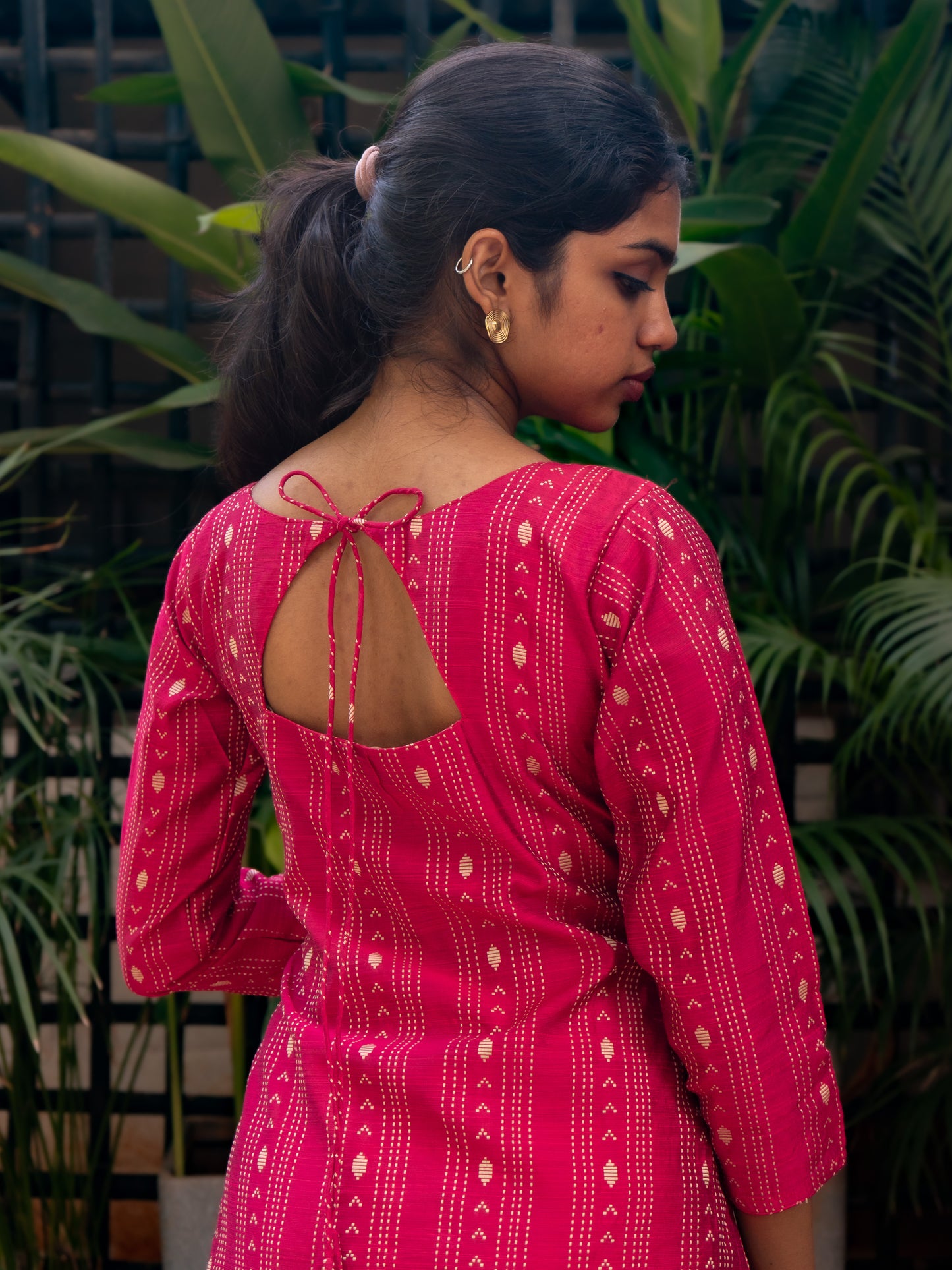Close-up of triangular back cut with tie detail on bright pink silk cotton kurti from Sakyaa