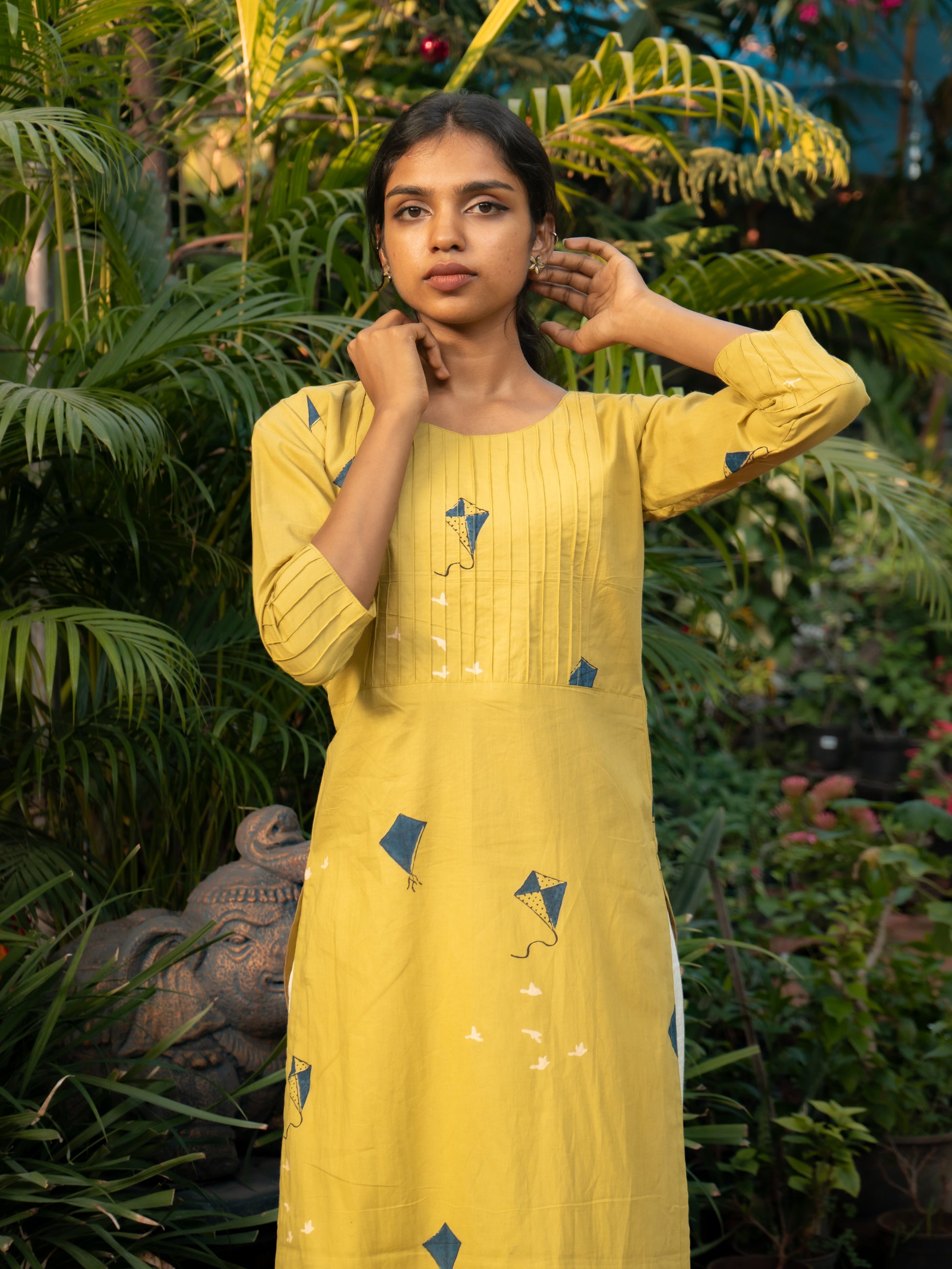 Front view of yellow cotton kurti with blue kite prints, pintuck detailing on yoke, and 3/4th sleeves from Sakyaa