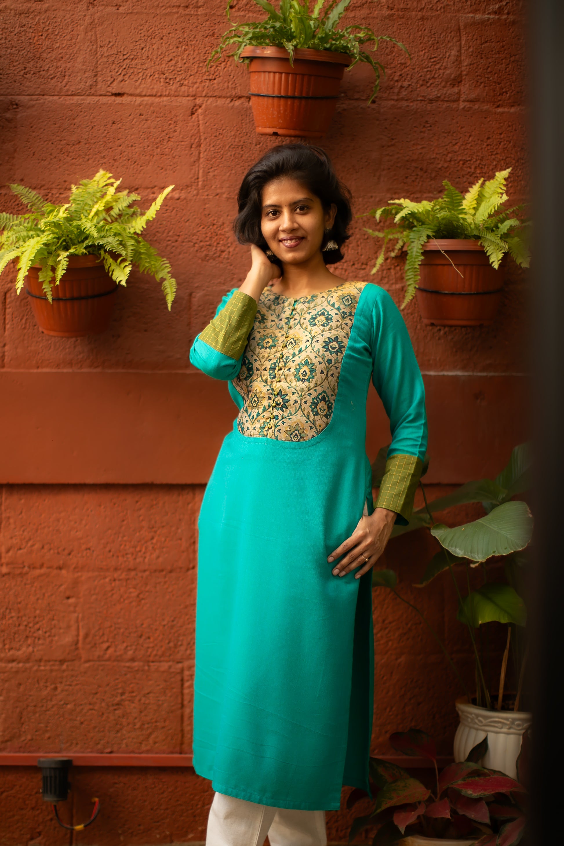 Lightweight teal cotton kurti with green sleeve borders detailed with light gold lines and a tissue yoke. Perfect for summer wear, office wear and casual wear.