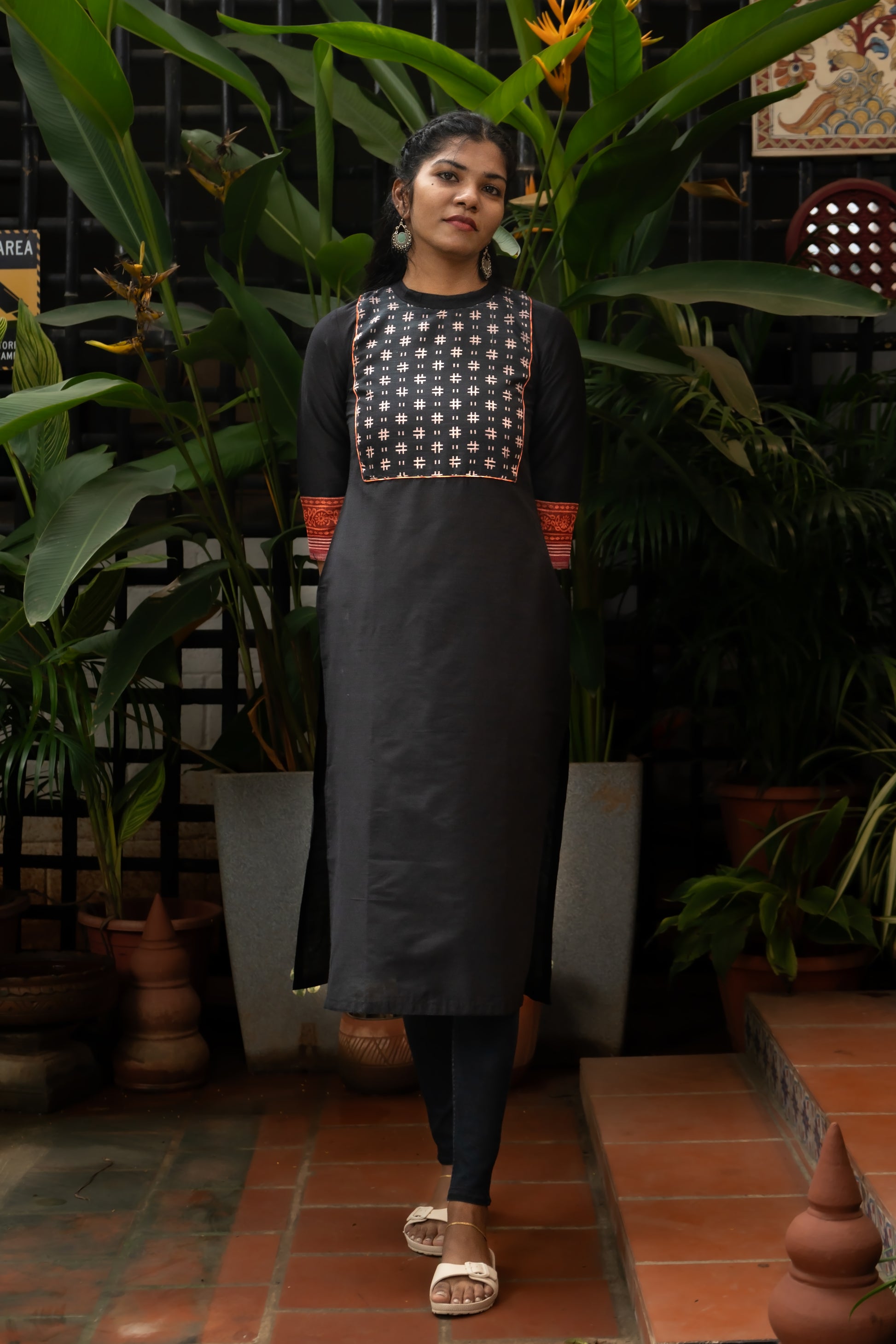 Elevate your ethnic wardrobe with this stunning black cotton silk kurti. The intricate ikat printed linen yoke, accented with a contrast rust linen border, adds a touch of bohemian charm. The classic close neck and back hook fastening ensure a comfortable and stylish fit. Crafted from soft and breathable fabrics, this kurti offers both comfort and style. Pair it with your favorite leggings or jeans for a chic and effortless look.