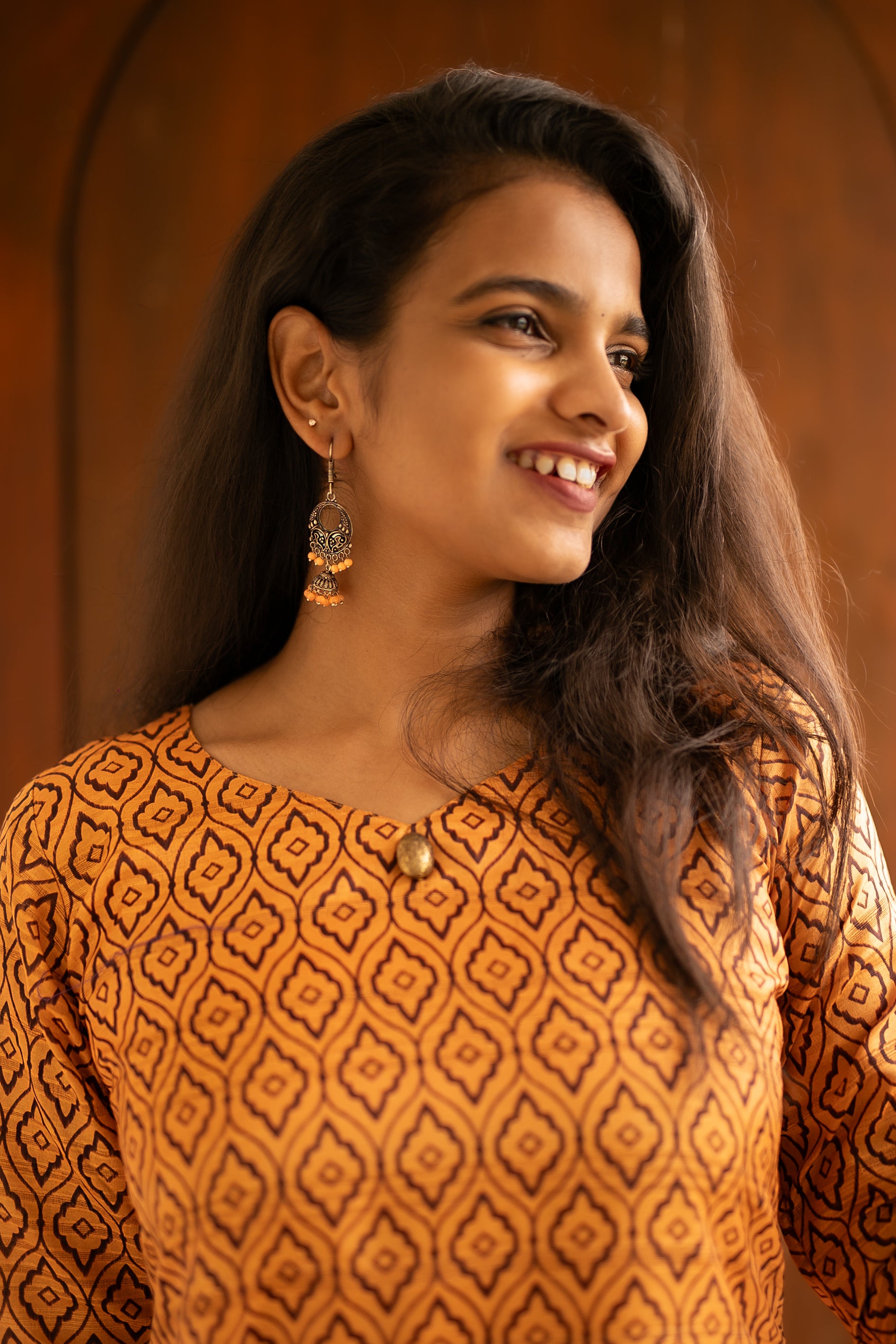 A Classic Sakyaa design featuring semi tussar fabric, lined with a warm and elegant gold lace and 3/4th sleeves. Accessorised with a simple oxidised hanging earing