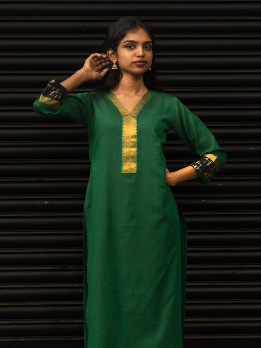 Mid-length view highlighting black Pochampally sleeve borders and gold detailing on green Mangalgiri cotton kurti, in-house stitched by Sakyaa.