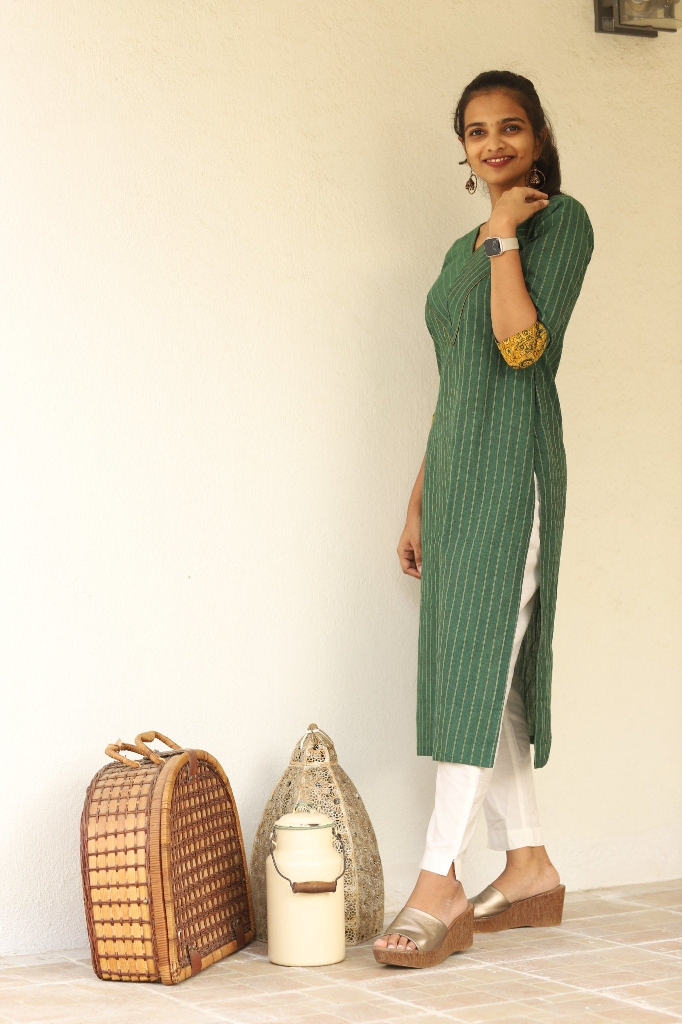 The model is posing with a green cotton Kurti with ajrakh detailing 